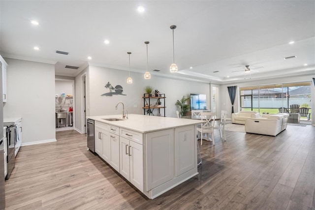 6879 Talamore Dr, Wesley Chapel, FL 33545 - kitchen featuring a ceiling fan, light wood-style flooring, open floor plan, a kitchen island with sink, and white cabinets