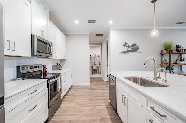 6879 Talamore Dr, Wesley Chapel, FL 33545 - kitchen with stainless steel appliances, decorative backsplash, ornamental molding, light countertops, and white cabinetry
