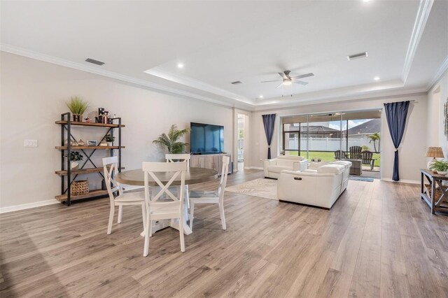 6879 Talamore Dr, Wesley Chapel, FL 33545 - dining room featuring a raised ceiling, light wood finished floors, ceiling fan, crown molding, and recessed lighting