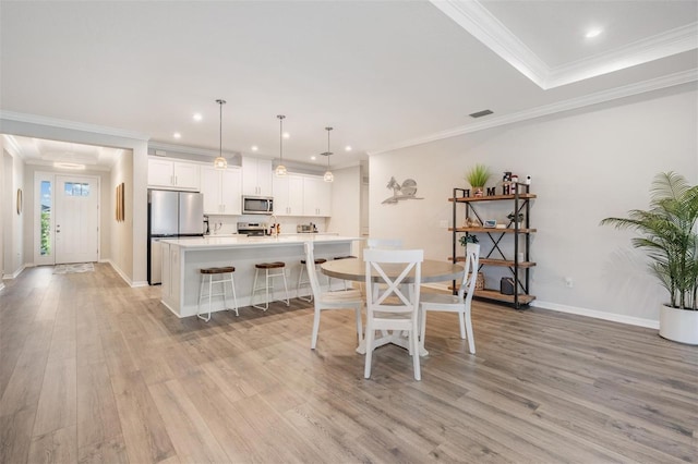 6879 Talamore Dr, Wesley Chapel, FL 33545 - dining area with light wood-style floors, recessed lighting, and ornamental molding