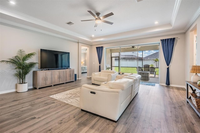 6879 Talamore Dr, Wesley Chapel, FL 33545 - living area with a ceiling fan, wood finished floors, a tray ceiling, crown molding, and recessed lighting