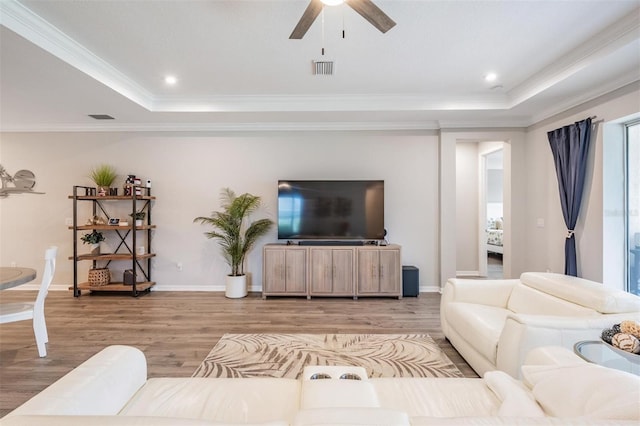 6879 Talamore Dr, Wesley Chapel, FL 33545 - living area with a raised ceiling, ceiling fan, ornamental molding, light wood-type flooring, and recessed lighting