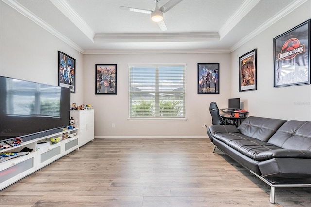 6879 Talamore Dr, Wesley Chapel, FL 33545 - living room featuring a raised ceiling, light wood-type flooring, ornamental molding, and ceiling fan