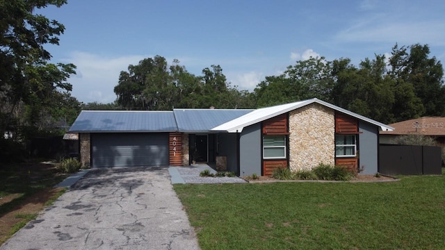 4041 SE 20th Ct, Ocala, FL 34480 - view of front of property with an attached garage, a front yard, asphalt driveway, and a metal roof