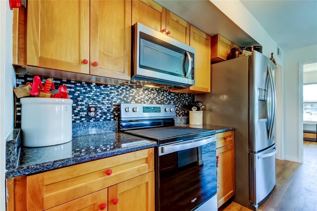 5722 Biscayne Ct Unit 107, New Port Richey, FL 34652 - kitchen with appliances with stainless steel finishes, tasteful backsplash, light wood finished floors, and dark stone countertops