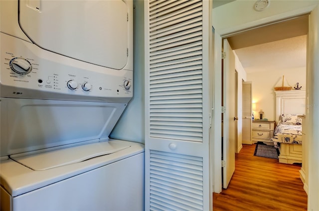 5722 Biscayne Ct Unit 107, New Port Richey, FL 34652 - laundry room featuring stacked washer / drying machine and wood finished floors