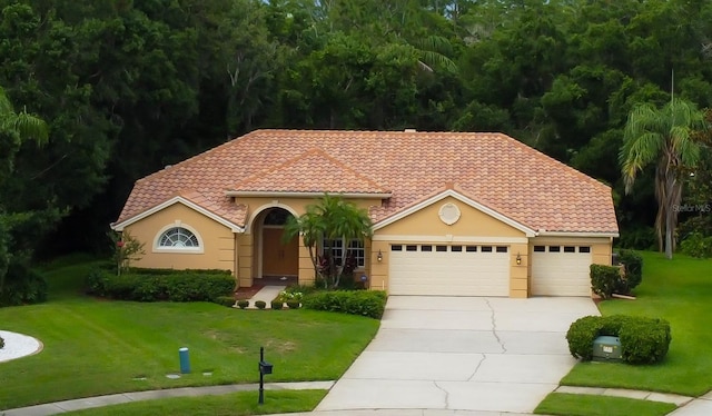 1827 Foxboro Ct, Oldsmar, FL 34677 - mediterranean / spanish-style home featuring concrete driveway, a tiled roof, a garage, a front lawn, and stucco siding