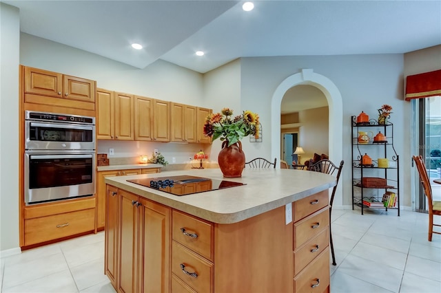 1827 Foxboro Ct, Oldsmar, FL 34677 - kitchen with stainless steel double oven, light countertops, arched walkways, light tile patterned flooring, and black electric cooktop