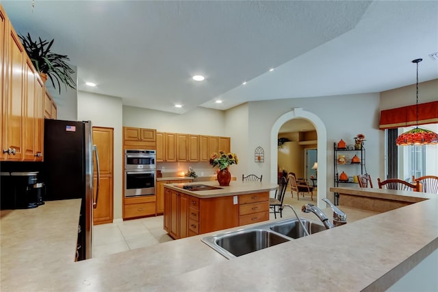 1827 Foxboro Ct, Oldsmar, FL 34677 - kitchen featuring appliances with stainless steel finishes, arched walkways, a center island, light countertops, and pendant lighting