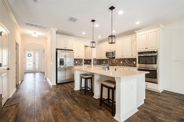 19209 Long Lake Ranch Blvd, Lutz, FL 33558 - kitchen with stainless steel appliances, arched walkways, backsplash, a breakfast bar, and crown molding