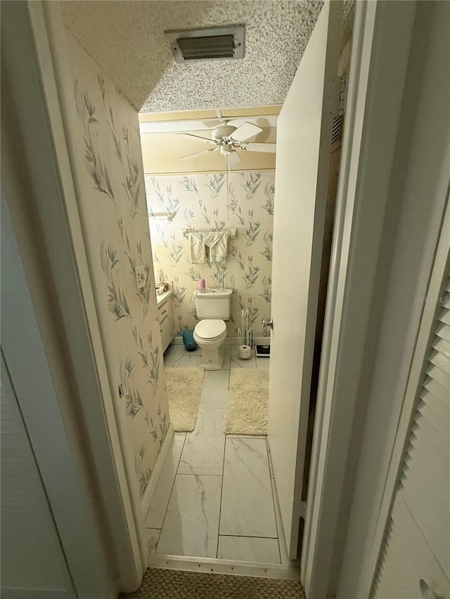 102 47th Avenue Dr W Unit 136, Bradenton, FL 34207 - bathroom featuring a ceiling fan, wallpapered walls, marble look tile flooring, and a textured ceiling