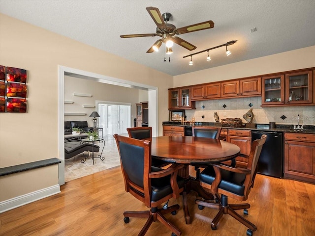 4118 Carrollwood Village Dr, Tampa, FL 33618 - dining room featuring wet bar, light wood-style floors, ceiling fan, rail lighting, and a textured ceiling
