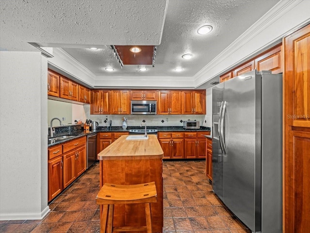 4118 Carrollwood Village Dr, Tampa, FL 33618 - kitchen with stainless steel appliances, ornamental molding, a textured ceiling, an island with sink, and butcher block countertops