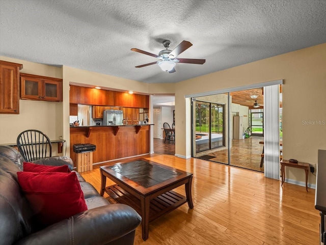 4118 Carrollwood Village Dr, Tampa, FL 33618 - living room featuring a ceiling fan, light wood-style floors, and a textured ceiling