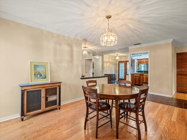 4118 Carrollwood Village Dr, Tampa, FL 33618 - dining room with a chandelier, wood finished floors, and crown molding