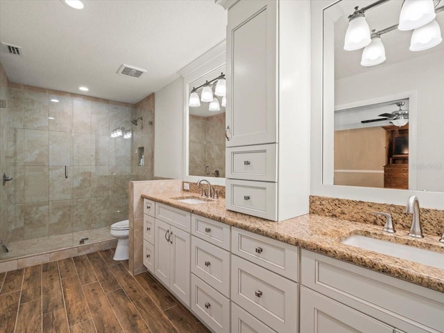 4118 Carrollwood Village Dr, Tampa, FL 33618 - bathroom featuring double vanity, a stall shower, wood finished floors, and recessed lighting