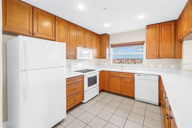 423 150th Ave Unit 1501, Madeira Beach, FL 33708 - kitchen featuring white appliances, light tile patterned floors, recessed lighting, light countertops, and brown cabinets