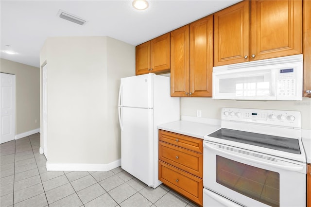 423 150th Ave Unit 1501, Madeira Beach, FL 33708 - kitchen with white appliances, light countertops, light tile patterned floors, brown cabinetry, and recessed lighting