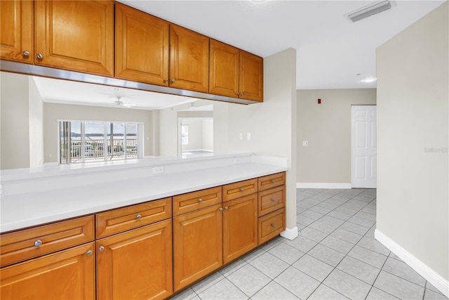 423 150th Ave Unit 1501, Madeira Beach, FL 33708 - kitchen featuring light countertops, brown cabinets, light tile patterned floors, and ceiling fan