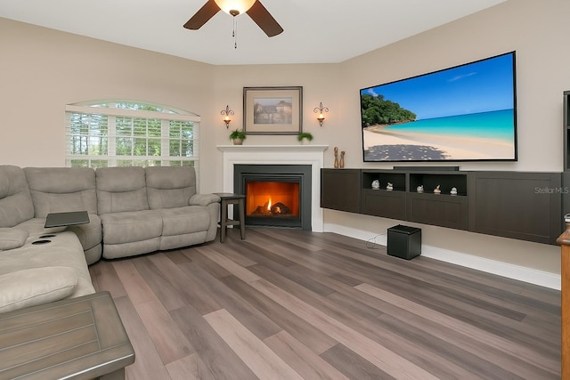 6513 Sand Shore Ln, New Port Richey, FL 34652 - living room featuring ceiling fan, a warm lit fireplace, and wood finished floors