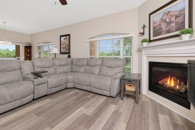 6513 Sand Shore Ln, New Port Richey, FL 34652 - living area featuring light wood-style floors, a ceiling fan, and a glass covered fireplace