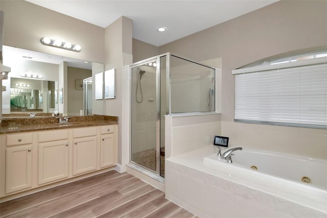 6513 Sand Shore Ln, New Port Richey, FL 34652 - bathroom with vanity, a shower stall, a jetted tub, and wood finished floors