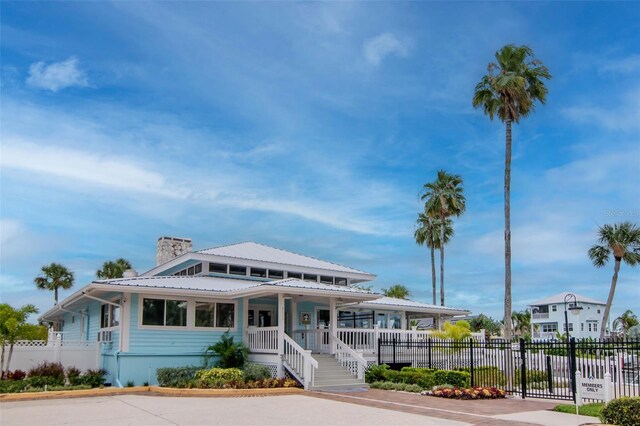 6513 Sand Shore Ln, New Port Richey, FL 34652 - view of front of property with a chimney, covered porch, and a metal roof