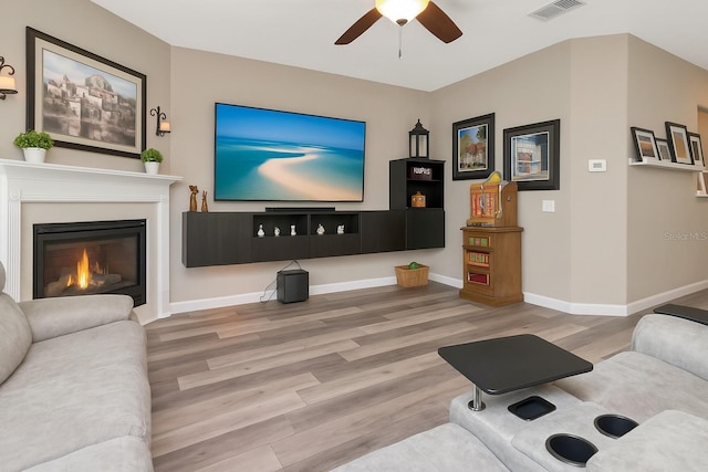 6513 Sand Shore Ln, New Port Richey, FL 34652 - living room featuring wood finished floors, a ceiling fan, and a glass covered fireplace