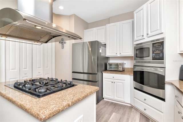 6513 Sand Shore Ln, New Port Richey, FL 34652 - kitchen featuring extractor fan, stainless steel appliances, white cabinets, light wood-style flooring, and a kitchen island