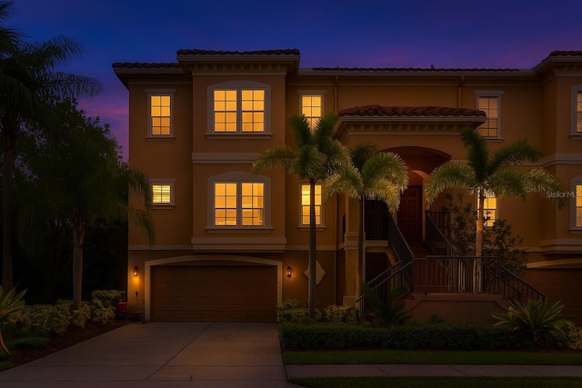 6513 Sand Shore Ln, New Port Richey, FL 34652 - mediterranean / spanish house with stucco siding, an attached garage, driveway, stairway, and a tile roof