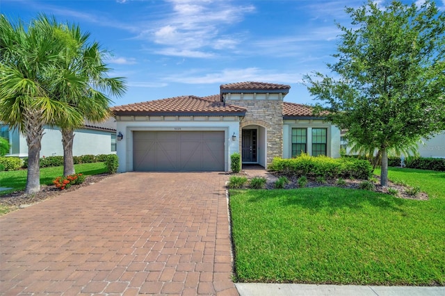 5320 Morey Farms Loop, Palmetto, FL 34221 - mediterranean / spanish-style house featuring stucco siding, a garage, decorative driveway, stone siding, and a front yard