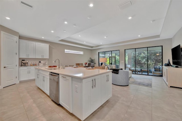 5320 Morey Farms Loop, Palmetto, FL 34221 - kitchen with a raised ceiling, stainless steel dishwasher, white cabinetry, open floor plan, and an island with sink