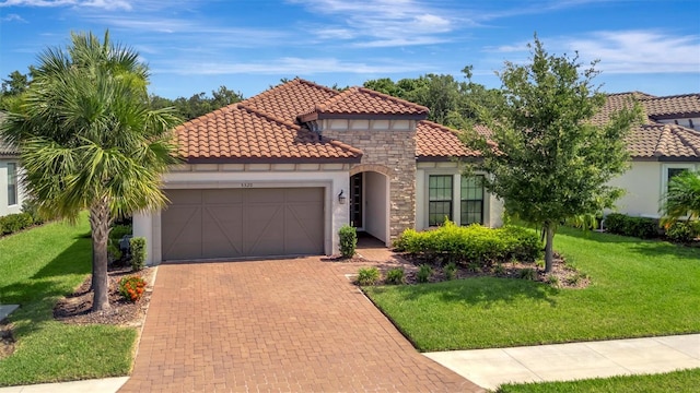 5320 Morey Farms Loop, Palmetto, FL 34221 - mediterranean / spanish house with an attached garage, stucco siding, a front lawn, and decorative driveway