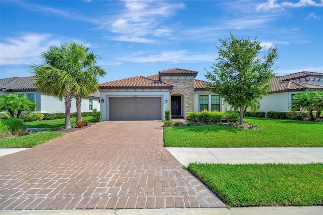 5320 Morey Farms Loop, Palmetto, FL 34221 - mediterranean / spanish-style house featuring decorative driveway, a garage, stucco siding, a front lawn, and a tile roof