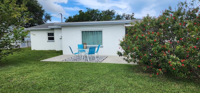 1583 Eunice Ln, Clearwater, FL 33756 - rear view of property featuring stucco siding, a yard, and a patio area