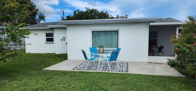 1583 Eunice Ln, Clearwater, FL 33756 - rear view of house with a patio, stucco siding, and a lawn