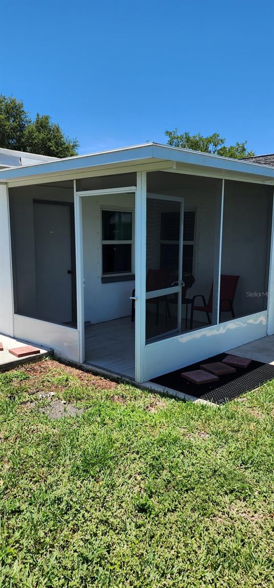 1583 Eunice Ln, Clearwater, FL 33756 - back of property featuring a sunroom and a yard