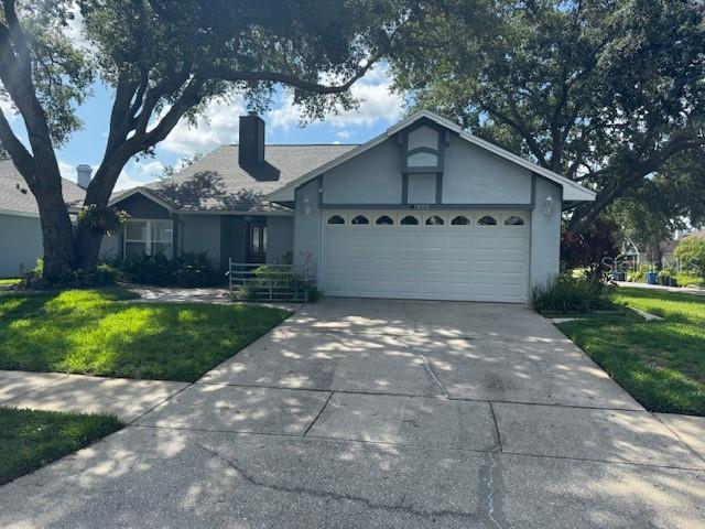 1922 Blue Sage Ct, Brandon, FL 33511 - ranch-style house featuring driveway, a garage, stucco siding, a front yard, and a chimney