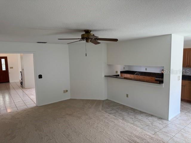 1922 Blue Sage Ct, Brandon, FL 33511 - unfurnished living room featuring ceiling fan, a textured ceiling, light colored carpet, and light tile patterned floors