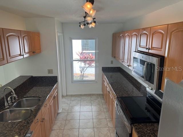 1922 Blue Sage Ct, Brandon, FL 33511 - kitchen featuring appliances with stainless steel finishes, a chandelier, dark stone countertops, and light tile patterned floors