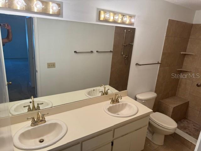 1922 Blue Sage Ct, Brandon, FL 33511 - full bath featuring double vanity, a tile shower, and tile patterned flooring
