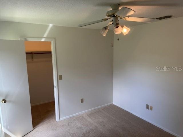 1922 Blue Sage Ct, Brandon, FL 33511 - unfurnished bedroom featuring a walk in closet, carpet, a closet, and a ceiling fan