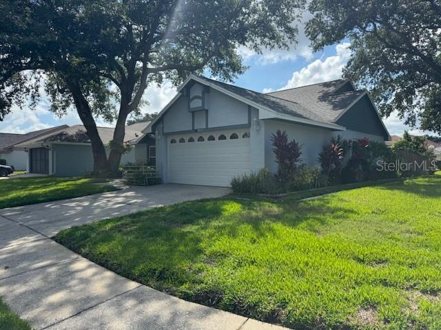 1922 Blue Sage Ct, Brandon, FL 33511 - view of front of property with a garage, a front yard, stucco siding, and concrete driveway