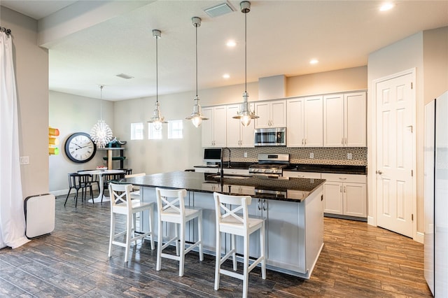 6817 Ebb Tide Ave, Apollo Beach, FL 33572 - kitchen featuring stainless steel appliances, backsplash, dark wood-type flooring, white cabinets, and recessed lighting