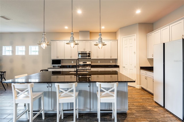 6817 Ebb Tide Ave, Apollo Beach, FL 33572 - kitchen featuring stainless steel appliances, tasteful backsplash, dark wood-style floors, white cabinets, and recessed lighting
