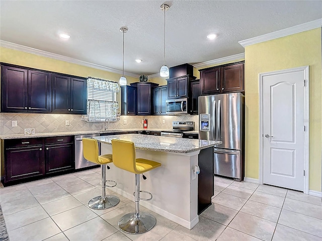 11703 Brighton Knoll Loop, Riverview, FL 33579 - kitchen with appliances with stainless steel finishes, light tile patterned floors, a kitchen island, light stone counters, and crown molding