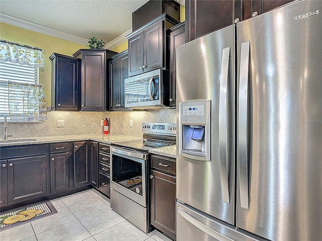 11703 Brighton Knoll Loop, Riverview, FL 33579 - kitchen featuring stainless steel appliances, ornamental molding, decorative backsplash, light stone countertops, and light tile patterned flooring