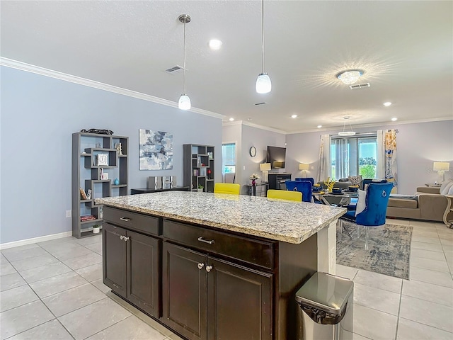 11703 Brighton Knoll Loop, Riverview, FL 33579 - kitchen featuring light tile patterned flooring, open floor plan, crown molding, decorative light fixtures, and light stone countertops