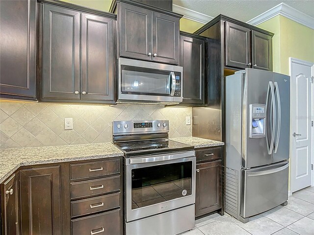 11703 Brighton Knoll Loop, Riverview, FL 33579 - kitchen featuring appliances with stainless steel finishes, crown molding, light tile patterned floors, light stone countertops, and tasteful backsplash
