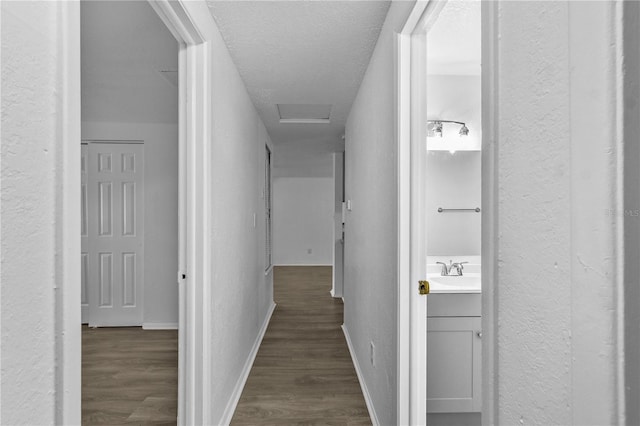 1116 Jadewood Ave, Clearwater, FL 33759 - hallway featuring a textured wall, dark wood-type flooring, and attic access